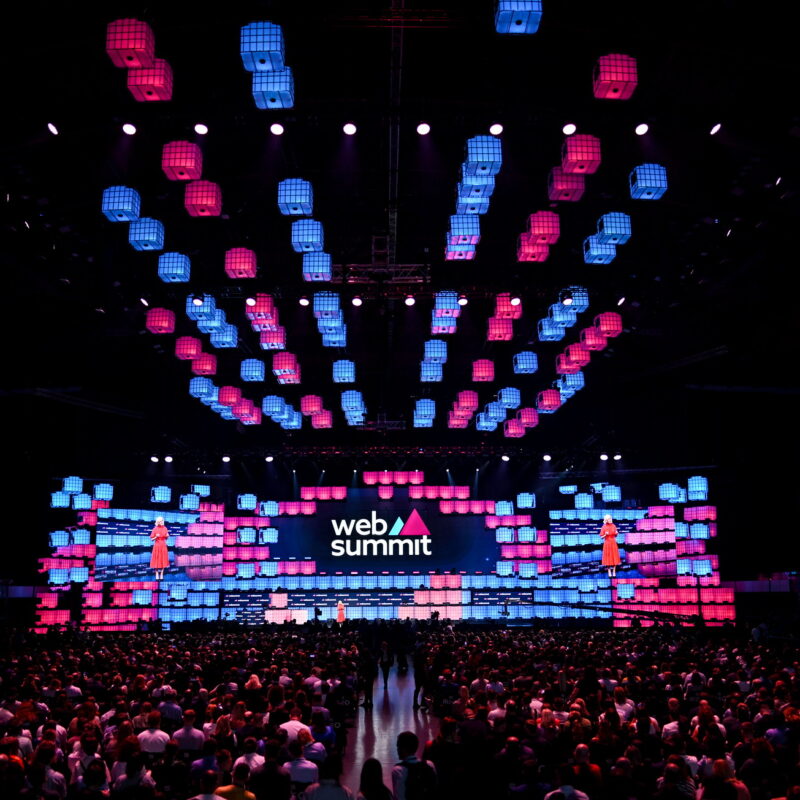 Photo of stage at Web Summit, with a packed audience.
