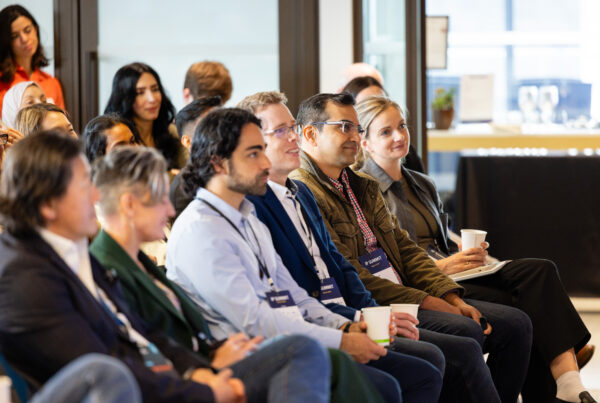 Attendees seated at the NVBC IP Summit, listening attentively to a panel of speakers at the front of the room.