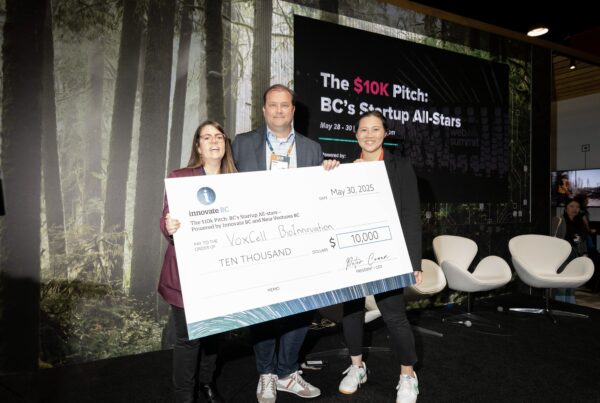Angie Schick, Peter Cowan, and Dr. Karolina Valente smiling and holding a large $10,000 cheque at the award presentation.