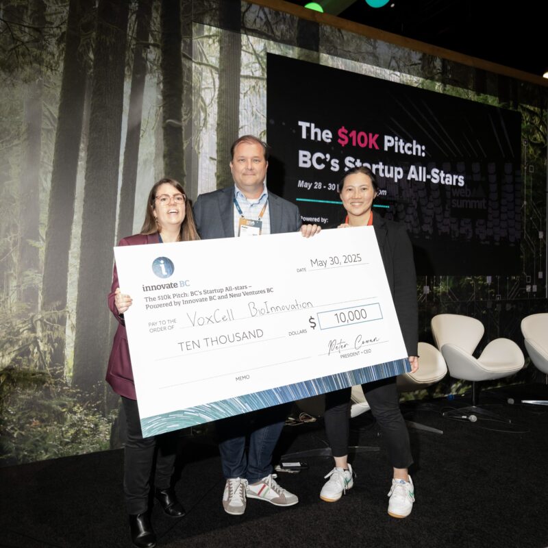 Angie Schick, Peter Cowan, and Dr. Karolina Valente smiling and holding a large $10,000 cheque at the award presentation.