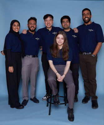 Metallyze team photo in front of blue background